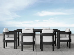 A black and white dining table surrounded by elegant white chairs, creating a modern and stylish dining space.