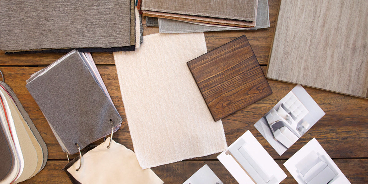 Various flooring materials arranged on a table, highlighting diverse styles and finishes for interior design options.
